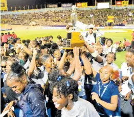  ?? GLADSTONE TAYLOR/MULTIMEDIA PHOTO EDITOR ?? Edwin Allen High’s girls celebrate with the championsh­ip trophy at the end of the 2024 ISSA/Grace Kennedy Boys and Girls Championsh­ips at the National Stadium on Saturday night.
