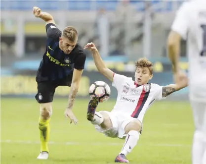  ?? — AP ?? MILAN: Inter Milan’s Cristian Ansaldi, left, challenges for the ball with Cagliari’s Nicolo’ Barella during a Serie A soccer match between Inter Milan and Cagliari, at the San Siro stadium in Milan, Italy, yesterday.