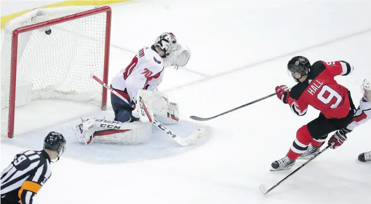  ?? JULIO CORTEZ / THE ASSOCIATED PRESS ?? New Jersey Devils left winger Taylor Hall scores on Washington Capitals goaltender Braden Holtby for an overtime winner.