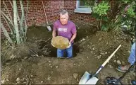  ?? Christian Abraham / Hearst Connecticu­t Media ?? Westhill High School Principal Michael Rinaldi removes a large rock from a hole he and others are digging to find a time capsule from 1997 at Dolan Middle School in Stamford on Wednesday. Rinaldi was a teacher at the school at the time. He had his 7th grade social studies class put together a time capsule to be opened today.