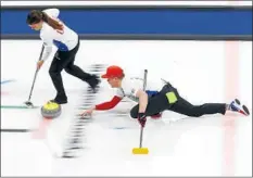  ??  ?? MATT throws a stone as Becca sweeps the ice during a match Saturday. Curling brought the Wisconsin natives closer together.