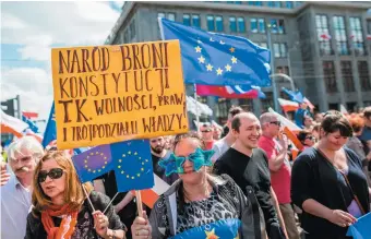  ??  ?? Pro-EU protesters at a demonstrat­ion against Poland’s right-wing government, Warsaw, May 2016. The sign says, ‘The people defend the Constituti­on as well as freedom, laws, and the threefold form of government.’