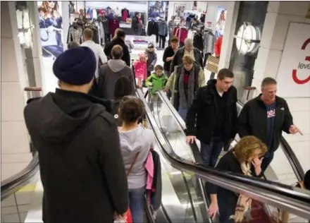  ?? ASSOCIATED PRESS FILE PHOTO — ANDREW A. NELLES ?? Shoppers ride escalators in this file photo. Retailers are hoping area residents fill up their stores this holiday season as well.