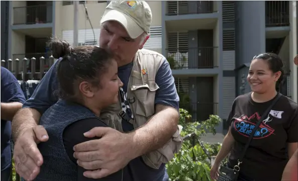  ?? ERIC ROJAS — THE NEW YORK TIMES ?? José Andrés, the Spanish chef who founded World Central Kitchen, embraces a local resident as he joins volunteers in delivering food to people displaced by Hurrican Maria in Naguabo, Puerto Rico, on Oct. 19, 2017. Long before the killings of seven workers in Gaza, World Central Kitchen pioneered a new way to deliver emergency relief, using local labor and recipes.