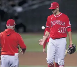  ?? PHOTOS BY JED JACOBSOHN — THE ASSOCIATED PRESS ?? Angels pitcher Steve Cishek, right, is taken out of the game by manager Joe Maddon during the sixth inning against the Oakland Athletics on Tuesday.