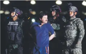  ??  ?? Mexican military personnel escort drug lord Joaquin “El Chapo” Guzman to a helicopter at Mexico City’s airport Friday night. Antonio Nava, AFP/Getty Images