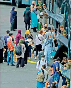  ?? AFP ?? Passengers embark onto buses upon the arrival of a chartered Air Belgium airplane Airbus A340 carrying evacuated people from Afghanista­n, at the military airport in Melsbroek, on Thursday. —