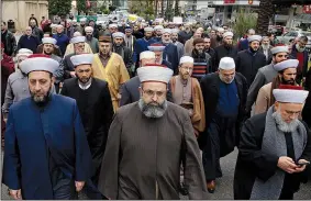  ?? AP/BILAL HUSSEIN ?? Lebanese Sunni clerics march Sunday in front of the Russian Embassy in Beirut during a protest in solidarity with residents of Ghouta, an eastern suburb of Damascus, Syria.