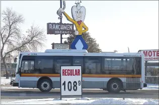  ?? NEWS PHOTO COLLIN GALLANT ?? A city bus drives past a gas station sign in the city’s Southwest Industrial area on Thursday afternoon.