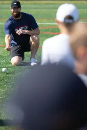  ?? MICHAEL JOHNSON — THE NEWS-HERALD ?? Corey Kluber rolls a ground ball to a camper during his baseball camp June 21 at Mentor High School.