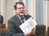  ?? JACQUES BOISSINOT LA PRESSE CANADIENNE ?? Le ministre de l’Éducation, Bernard Drainville, tient une copie de son projet de loi 23 dans le Salon bleu de l’Assemblée nationale.