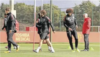  ??  ?? CARRINGTON: Manchester United manager Jose Mourinho, right, looks at his players during a training session in Carrington, Manchester, England yesterday. United are preparing for their Champions League group stage soccer match against Basel today. — AP