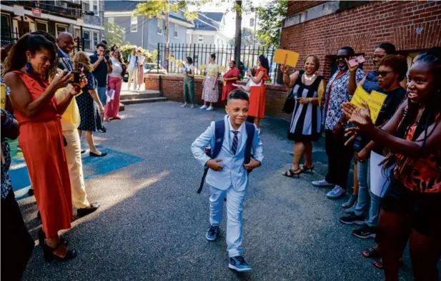  ?? ERIN CLARK/GLOBE STAFF ?? Students were greeted by rows of staff, politician­s, and community members Thursday at the Holmes Innovation School in Dorchester.