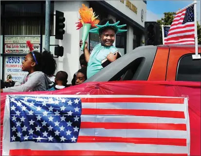  ?? CHRIS RILEY — TIMES-HERALD ?? Reign Johnson, dressed as the Statue of Liberty, smiles at the crowd as she rides in front of the Jesse Bethel Cheer team during a past Fourth of July Parade in Vallejo.