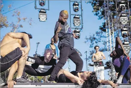  ?? Photograph­s by Bethany Mollenkof
Los Angeles Times ?? THE BRITISH KRUMPER who goes by “Dominant” undulates above the prone FKA Twigs on Aug. 23 at downtown’s FYF Fest.