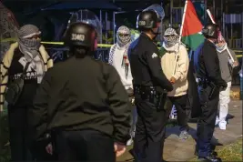  ?? HANS GUTKNECHT — LOS ANGELES DAILY NEWS/SCNG ?? Pro-Palestine protesters walk past officers in Los Angeles on Friday while President Biden was attending a fundraiser at a home nearby.