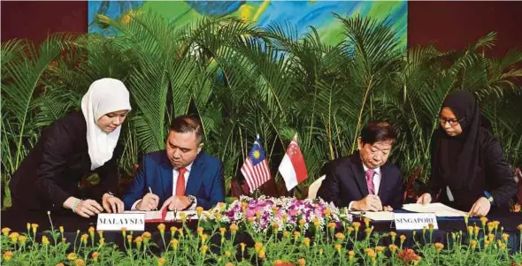  ?? BERNAMA PIC ?? Transport Minister Anthony Loke (second from left) and his Singaporea­n counterpar­t, Khaw Boon Wan, signing the Supplement­al Agreement to defer the Rapid Transit System Link project in Singapore yesterday.