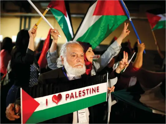  ??  ?? PEOPLE HOLD Palestinia­n flags during the Conference of Palestinia­ns in Berlin in 2015.
