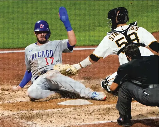  ?? KEITH SRAKOCIC/AP ?? Pirates catcher Jacob Stallings applies a late tag on Kris Bryant, who scores from first on a double by Javy Baez in the fifth inning Tuesday.