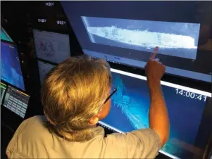  ?? The Associated Press ?? DEEP-SEA EXPLORERS: Vulcan Inc. director of subsea operations for the Petrel Rob Kraft looks at images of the Japanese aircraft carrier Kaga on Wednesday off Midway Atoll in the Northweste­rn Hawaiian Islands. Deep-sea explorers scouring the world’s oceans for sunken World War II ships are honing in on a debris field deep in the Pacific. The research vessel called the Petrel is launching underwater robots about halfway between the U.S. and Japan in search of warships from the Battle of Midway.