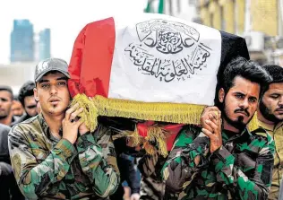  ?? Haidar Hamdani / AFP via Getty Images ?? Mourners carry a coffin draped with the Iraqi national flag during a funeral for members of the Hashed al-Shaabi paramilita­ries who were killed in U.S. airstrikes.