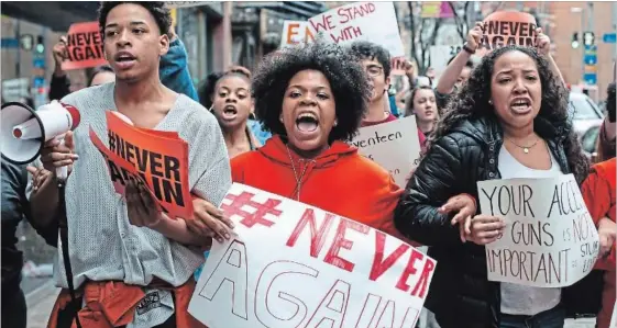  ?? STEPHANIE STRASBURG THE ASSOCIATED PRESS ?? High school students Mia Arrington, centre, and Cheyenne Springette march down Liberty Avenue during a walk-out in solidarity with others to show support for Parkland, Fla., students.