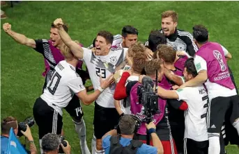  ??  ?? German midfielder Toni Kroos celebrates with team-mates after scoring the dramatic winning goal in injury time against Sweden. GETTY IMAGES