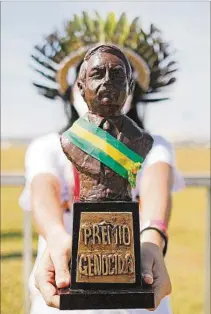  ??  ?? ACTITUD. Un militante muestra el “premio” dedicado a Bolsonaro.