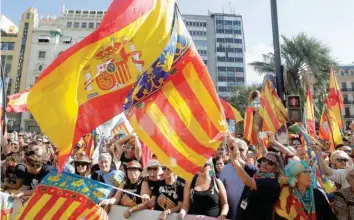  ?? — Reuters ?? Right-wing demonstrat­ors waving Spanish and Valencian flgs insult local leftist politician­s accusing them of sympathisi­ng with the Catalan separatist movement during the festivitie­s of the regional day in Valencia, Spain, on Monday.