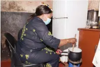  ?? ?? First Lady Dr Auxillia Mnangagwa prepares sorghum porridge which is rich in nutrients for Mr Stephen Muchato who had not eaten anything since morning during the visit in Mabvuku on Monday