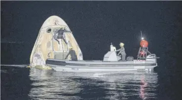  ??  ?? 0 Support teams working around the Spacex spacecraft shortly after it landed