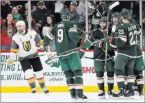  ?? Stacy Bengs ?? The Associated Press The Wild scored the game’s opening goal, in the second period by Mikael Granlund, who is concealed by a crowd of joyous teammates.