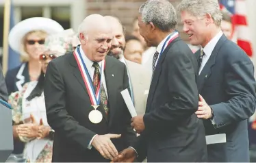  ?? ?? TOM MIHALEK / AFP VIA GETTY IMAGES
From left, then-South African president F.W. de Klerk clasps hands with freedom fighter Nelson Mandela as U.S. President Bill Clinton looks on. De Klerk and Mandela received the Philadelph­ia Liberty Medal on July 4, 1993.