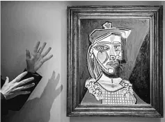  ??  ?? James Mackie (left), Sotheby’s senior director and head of the Department Impression­ist and Modern Art, introduces Pablo Picasso’s 1937 oil painting ‘Femme au béret et à la robe quadrillée’ (Marie-Thérèse Walter) during a media preview at the Sotheby’s...