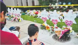  ?? Brendan Smialowski, AFP/Getty Images ?? People pay their respects at a memorial outside the Tree of Life Synagogue on Monday in Pittsburgh.