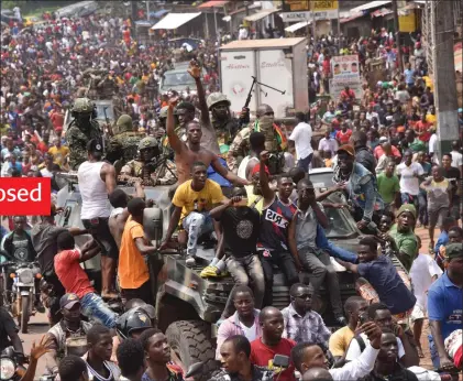  ?? Photo: Nampa/AFP ?? Taking over… People celebrate in the streets with members of Guinea’s armed forces after the arrest of Guinea’s president, Alpha Conde, in a coup d’etat in Conakry.