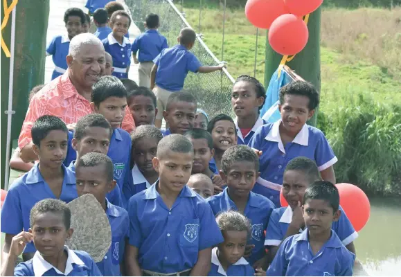  ?? Photo: Josaia Ralago ?? Korortari Primary School students with Prime Minister Voreqe Bainimaram­a on the newly-opened Korotari Suspension Bridge on June 21, 2017.