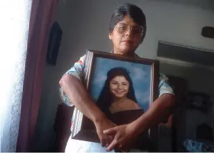  ?? All photos are SCNG file photos. ?? Mary Bennett, above, holds a photograph of her daughter, Cathy Torrez, an honors student at Cal State Fullerton, who was found dead in the trunk of her car in February 1994.