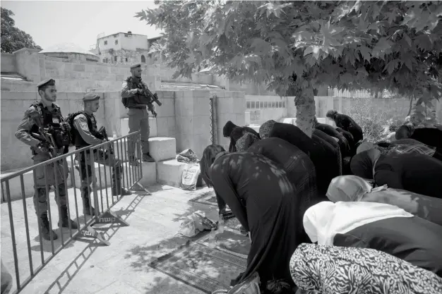  ??  ?? Palestinia­ns women pray at the Lion's Gate following an appeal from clerics to pray in the streets instead of inside the Al Aqsa Mosque compound, in Jerusalem's Old City, Tuesday, July 25, 2017. (AP)