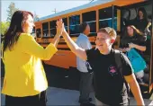  ?? Los Angeles Times/tns ?? Vice Principal Jillian Damon, left, greets students with a highfive as they return to class at Paradise High School, months after the Camp Fire ravaged the community in Paradise, Calif., on Thursday.