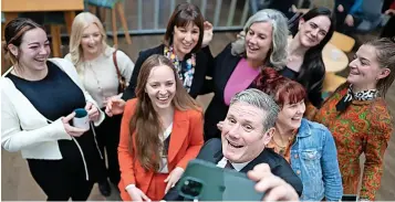  ?? Stefan Rousseau/PA ?? Labour leader Sir Keir Starmer takes a selfie of himself and shadow chancellor Rachel Reeves with a group of women entreprene­urs at a networking event, at the Workshed Foundry in Swindon