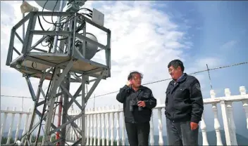  ?? PHOTSO BY ZOU HONG CHINA DAILY ?? Liu Jun and his wife, Qi Shuyan, on the roof of their watchtower in Saihanba.