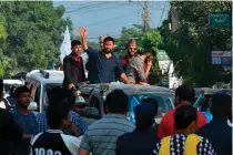  ?? AFP
PHOTO ?? WOOING VOTERS
In this picture taken on Saturday, Nov. 12, 2022, former television host and Independen­t Party’s candidate in Nepal’s general election Rabi Lamichhane (center) waves from atop a vehicle as he arrives for a door-to-door election campaign event in Padampur. As the Himalayan republic prepares for its November 20 general election, Lamichhane is one of several upstart candidates challengin­g the familiar faces that have walked the corridors of power for decades.