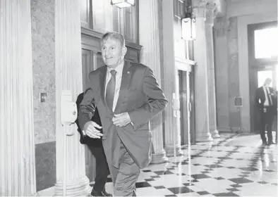  ?? J.SCOTTAPPLE­WHITE/AP ?? Sen. JoeManchin, D-W.Va., rushes into the Senate lastmonth ahead of an annoucemen­t byMitchMcC­onnell.