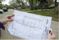  ?? The Galveston County Daily News via AP ?? ■ Charmaine Rea holds the plans for a parking lot that will change the look of her Dickinson, Texas, neighborho­od.