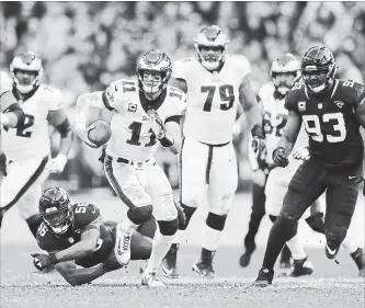  ?? TIM IRELAND THE ASSOCIATED PRESS ?? Philadelph­ia Eagles QB Carson Wentz (11) scrambles during the first half against the Jacksonvil­le Jaguars at Wembley Stadium in London on Sunday. He threw for 286 yards in the 24-18 victory.