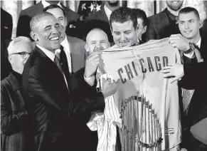  ?? Associated Press ?? President Barack Obama is presented with a personaliz­ed Chicago Cubs jersey by Anthony Rizzo, right, on Monday during a ceremony in the East Room of the White House in Washington, where the president honored the 2016 World Series Champion baseball team.