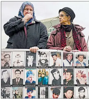  ??  ?? AP/PHIL NIJHUIS Women display images of war-crimes victims Wednesday outside the Internatio­nal Criminal Tribunal in The Hague, Netherland­s, as they wait for the verdict on former Serb warlord Ratko Mladic.