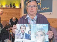  ?? FOTO: PAUL MARTIN ?? DFGK-Vorstand Rupert Hagel mit Flyern von Macron und Le Pen: Jeder Wahlberech­tigte hatte im Vorfeld Wahlinform­ationen zugeschick­t bekommen.