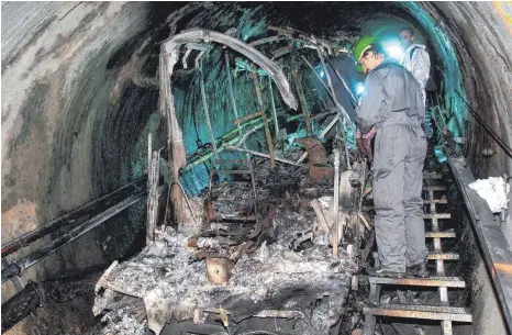 ?? FOTO: FRANZ NEUMAYR ?? Bergungsar­beiter inspiziere­n die Überreste der verbrannte­n Tunnel-Gletscherb­ahn am Kitzsteinh­orn bei Kaprun. Für viele Hinterblie­bene ist es völlig unverständ­lich, dass bisher niemand für diese Tragödie zur Verantwort­ung gezogen wurde.